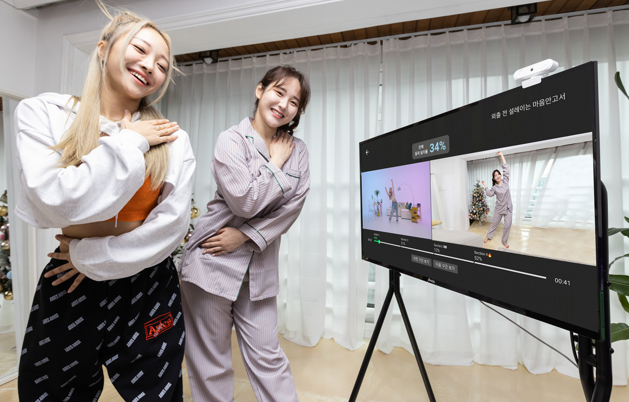 원밀리언댄스 소속 안무가 에이미 팍이 지니 TV의 원밀리언 홈댄스 AI 코칭 튜토리얼 서비스 체험을 돕고 있는 모습. [KT 제공]