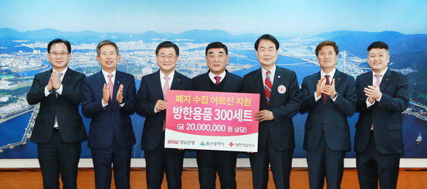 13일 울산시청에서 최홍영 BNK경남은행장(사진 왼쪽 세 번째)이 김두겸 울산시장(사진 왼쪽 네 번째)과 김철 대한적십자사 울산지사 회장에게 '폐지 수집 어르신 지원 방한용품 세트 기탁 증서'를 전달하고 있다. [사진=BNK경남은행]