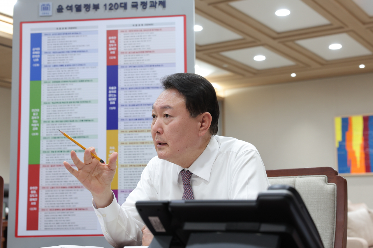 윤석열 대통령이 13일 윤석열정부 120대 국정과제 현황판이 설치된 용산 대통령실 청사 집무실에서 업무를 보고 있다. [연합]
