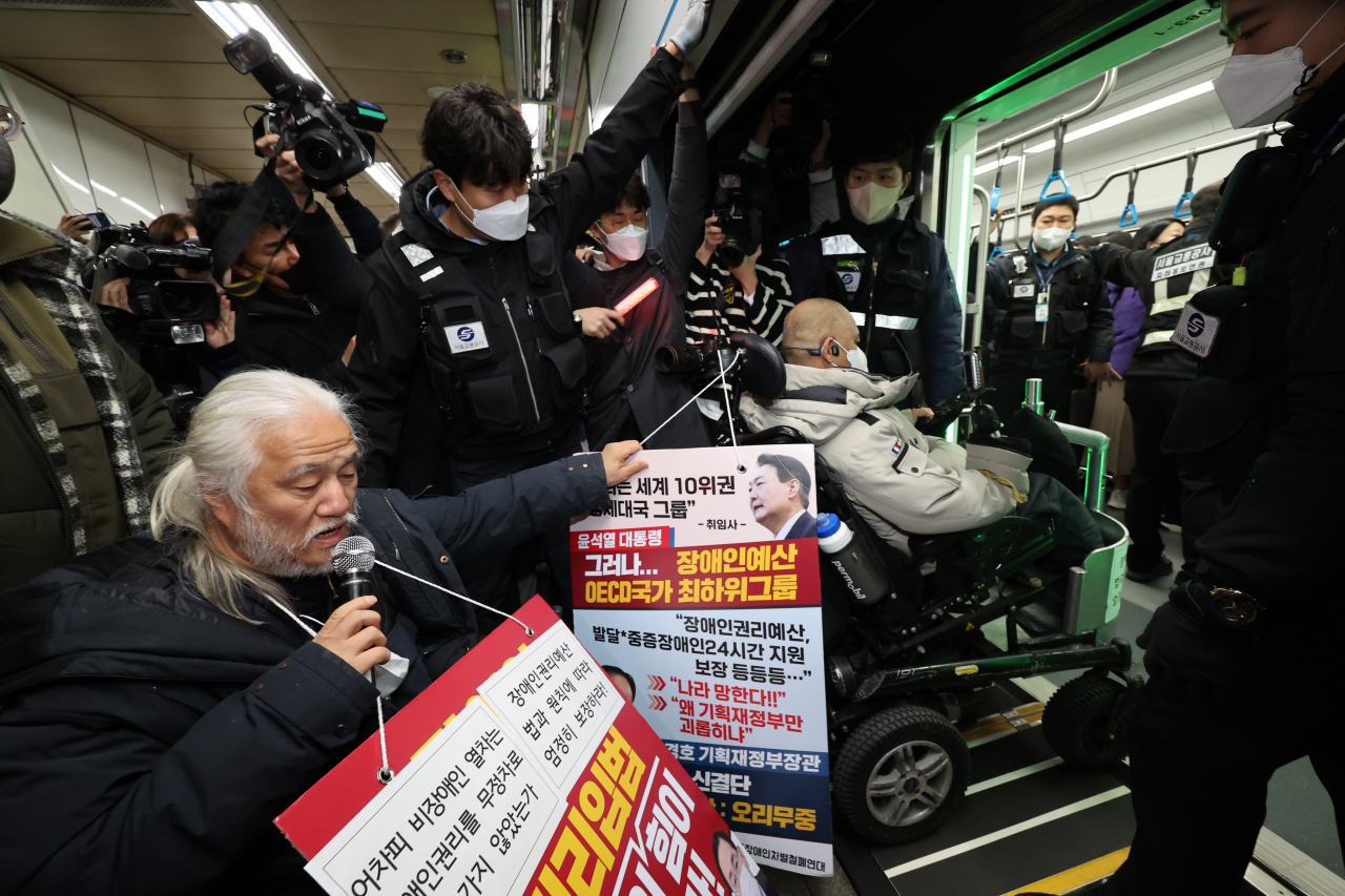 지난 13일 오전 전국장애인차별철폐연대(전장연) 회원들이 서울 용산구 4호선 삼각지역에서 출근길 지하철 탑승 시위를 하고 있다. [연합]