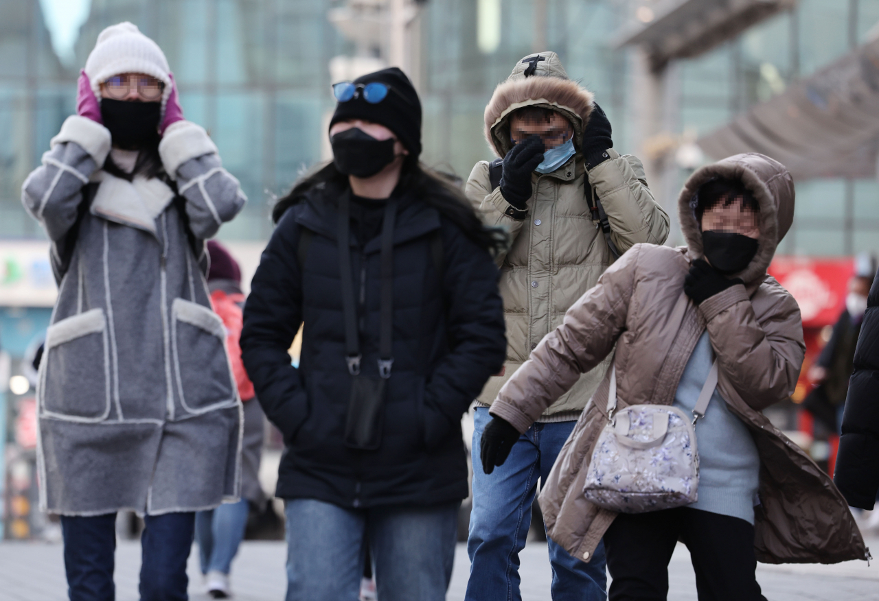 올겨울 한파가 시작된 14일 오후 서울 명동 거리에서 외국인 관광객들이 추위를 견디며 걸어가고 있다. [연합]