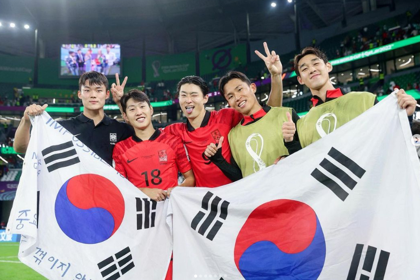 축구 국가대표팀의 '예비 멤버' 오현규(왼쪽)가 지난 3일 2022 카타르 월드컵 포르투갈전에서 한국의 승리 후 선수들과 태극기를 들고 포즈를 취하고 있다 [오현규 인스타그램 캡처]