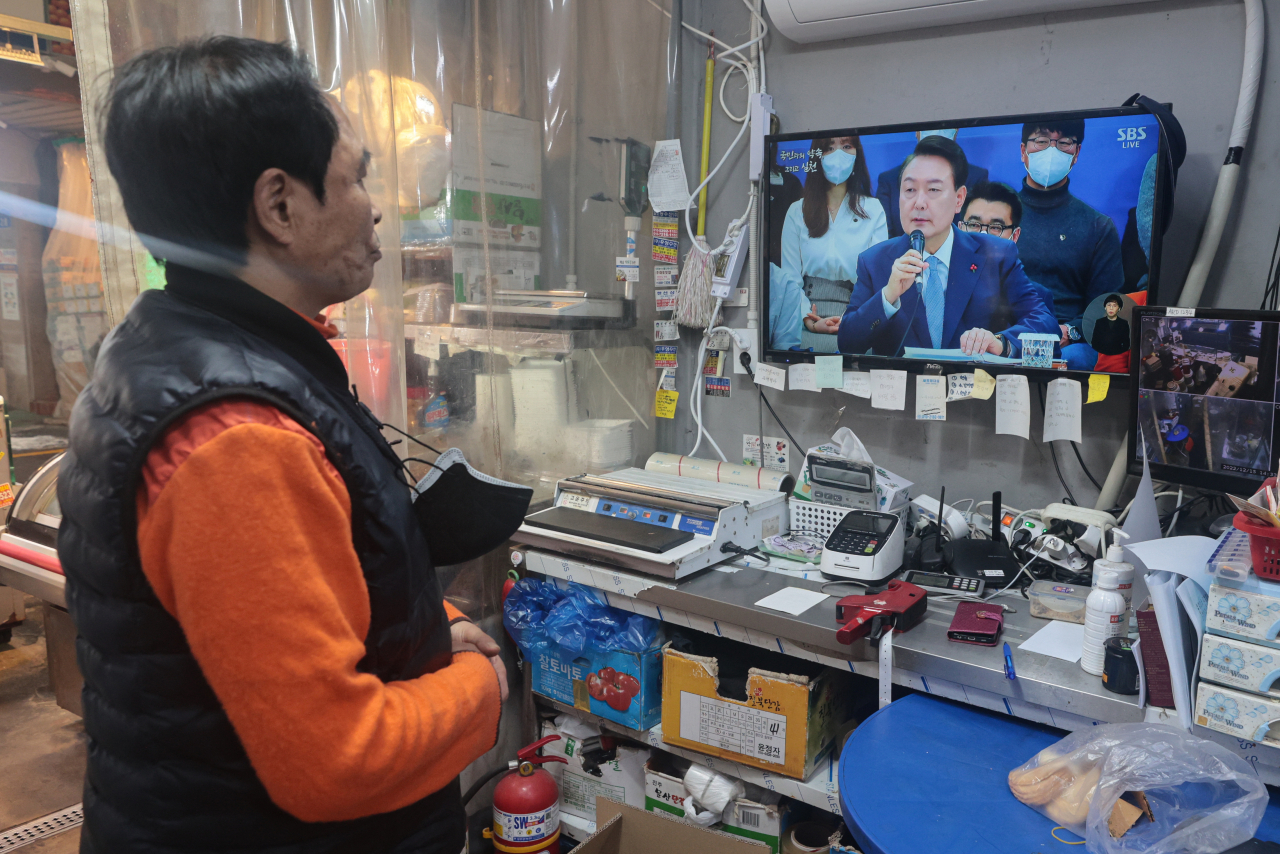 윤석열 대통령 주재로 제1차 국정과제점검회의가 열리는 15일 오후 서울 마포구 망원시장에서 한 상인이 중계방송을 시청하고 있다. [연합]