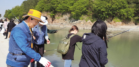 한국어촌어항공단 최우수상을 받은 천명길(왼쪽) 바다해설사가 관광객들과 함께 체험활동을 진행하고 있다. [한국어촌어항공단 제공]