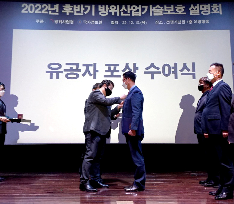 이영빈 방위사업청 국방기술보호국장(왼쪽)이 지난 15일 서울 용산 전쟁기념관에서 방위사업청과 국가정보원이 개최한 ‘방위산업기술보호 설명회’에서 박승수 LIG넥스원 프로(오른쪽)에게 배지를 달아주고 있다. [LIG넥스원 제공]