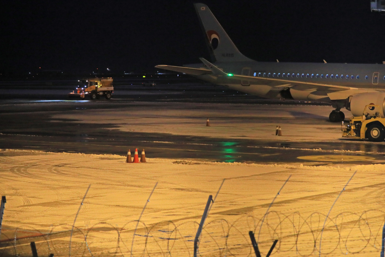 제주도에 대설특보가 발효된 18일 새벽 제설차량이 제주공항 활주로의 눈을 치우고 있다. [연합]