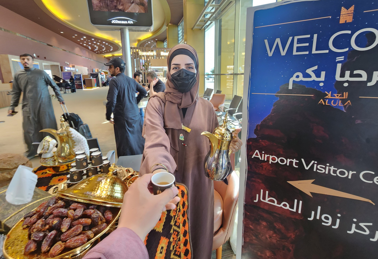 알울라 공항의 무료 다과를 건네는 공항 직원