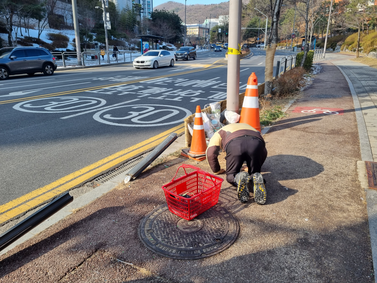 지난 19일 오후 서울 세곡동의 인도에서 한 주민이 같은 달 17일 버스에 치여 사망한 초등학생을 추모하기 위해 절을 하고 있다. 김영철 기자