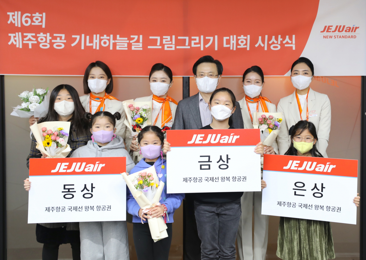 ‘제6회 기내 하늘길 그림 그리기 대회’에서 수상자들이 김이배 제주항공 대표이사, 객실승무원들과 기념사진을 찍고있다. [제주항공 제공]