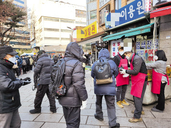 22일 오전 8시40분, 서울시 종로구 탑골공원 원각사 무료급식소 앞에서 사람들이 배식을 받고 있다. 박혜원 기자