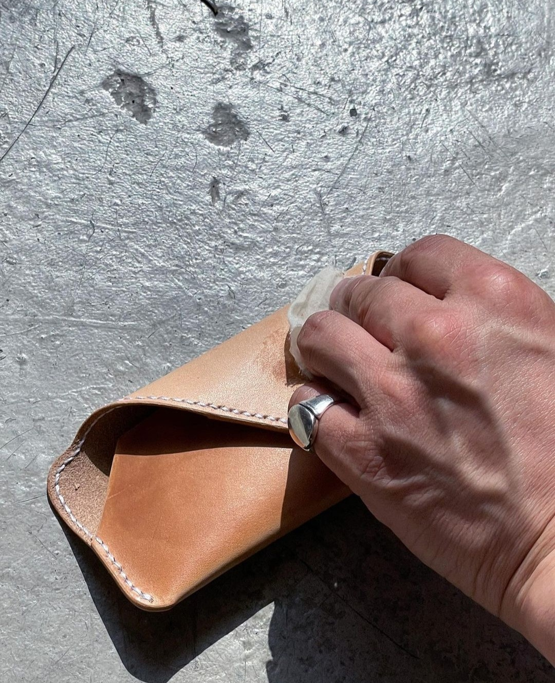 Leather oil applied on an eyeglass case during a leather craft workshop at Folki (Folki)
