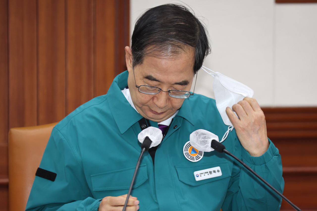한덕수 국무총리가 23일 정부서울청사에서 열린 '코로나19 중대본 회의를 주재하기 위해 마스크를 벗고 있다. 정부는 이날 코로나19 중대본 회의를 거쳐 실내 마스크 의무 조정안을 확정해 발표한다. [연합]