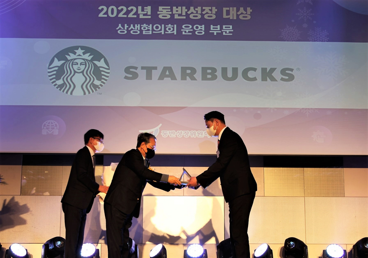 22일 서울 강남구 코엑스에서 개최된 '2022년 동반성장 대상'에서 손정현(오른쪽) 스타벅스 손정현 대표이사가 유장희 제2대 동반성장위원장(가운데)으로부터 상패를 수여받고 있다. [스타벅스 코리아 제공]