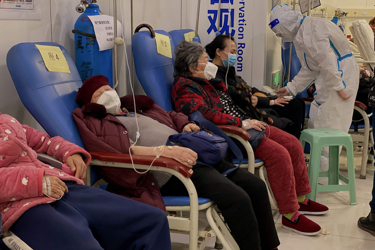지난 23일(현지시간) 중국 남서부 충칭시 충칭의과대학 제2부속병원에서 코로나19 환자들이 팔에 주사를 꽂은 채 줄지어 앉아있다. [연합]