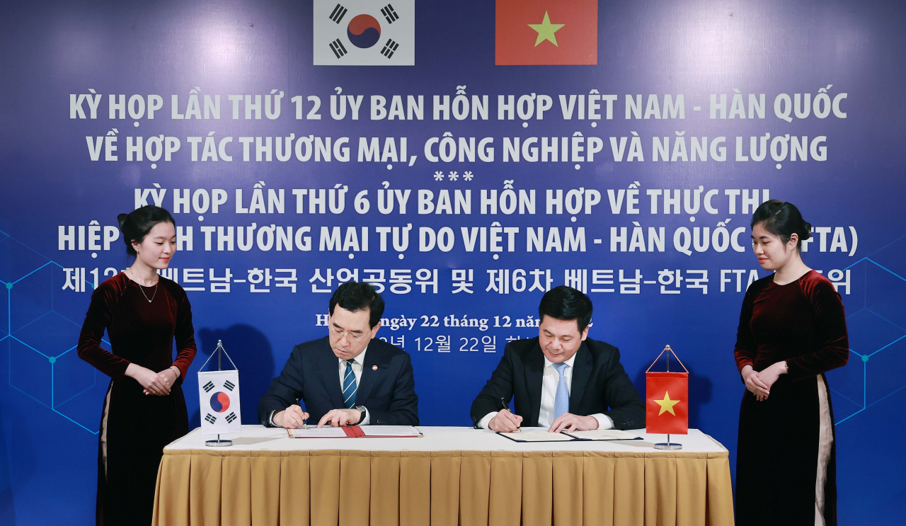 Industry Minister Lee Chang-yang (second from left) and his Vietnamese counterpart Nguyn Hng Di&ecirc;n (second from right) signing minutes on enhanced trade and investment in Hanoi last Thursday. (South Korea's industry ministry)