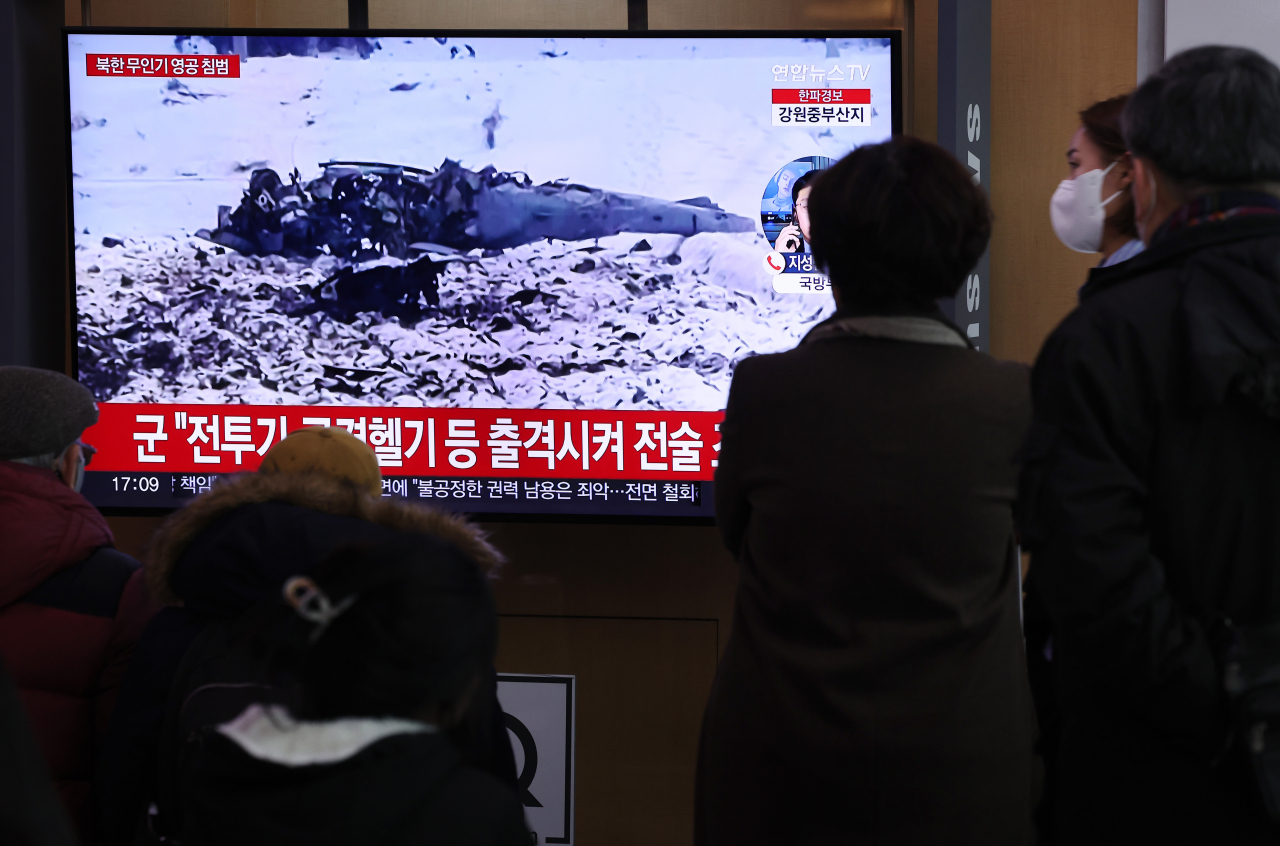 26일 서울역 대합실에서 시민들이 북한 무인기 영공 침범과 관련된 뉴스를 시청하고 있다. [연합]