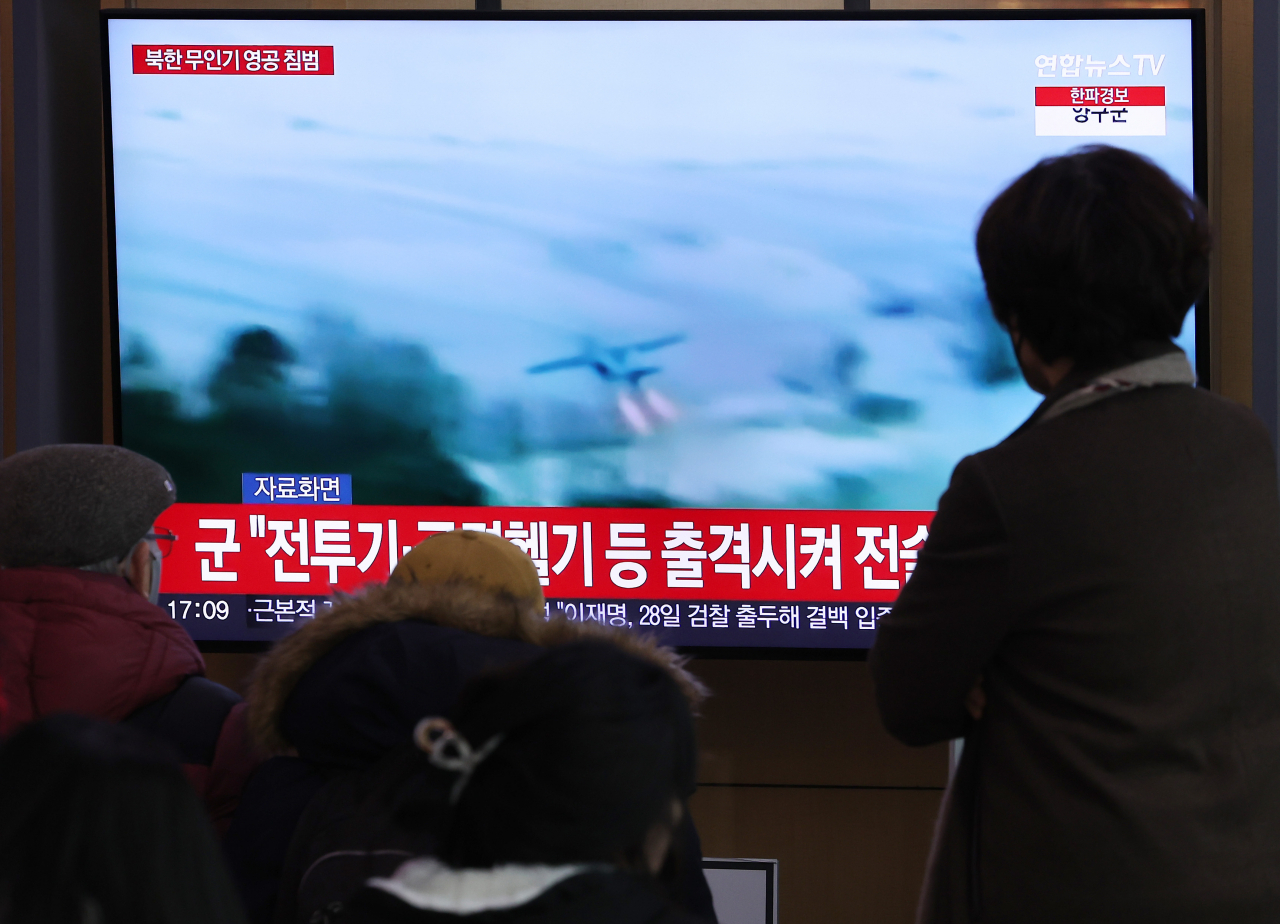 26일 서울역 대합실에서 시민들이 북한 무인기 영공 침범과 관련된 뉴스를 시청하고 있다. [연합]