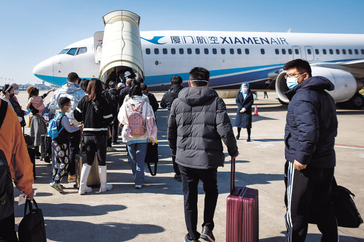 항공기 승객들이 지난 26일 중국 푸젠성 샤먼 가오치 국제공항에서 베이징행 여객기에 탑승하고 있다. [EPA]
