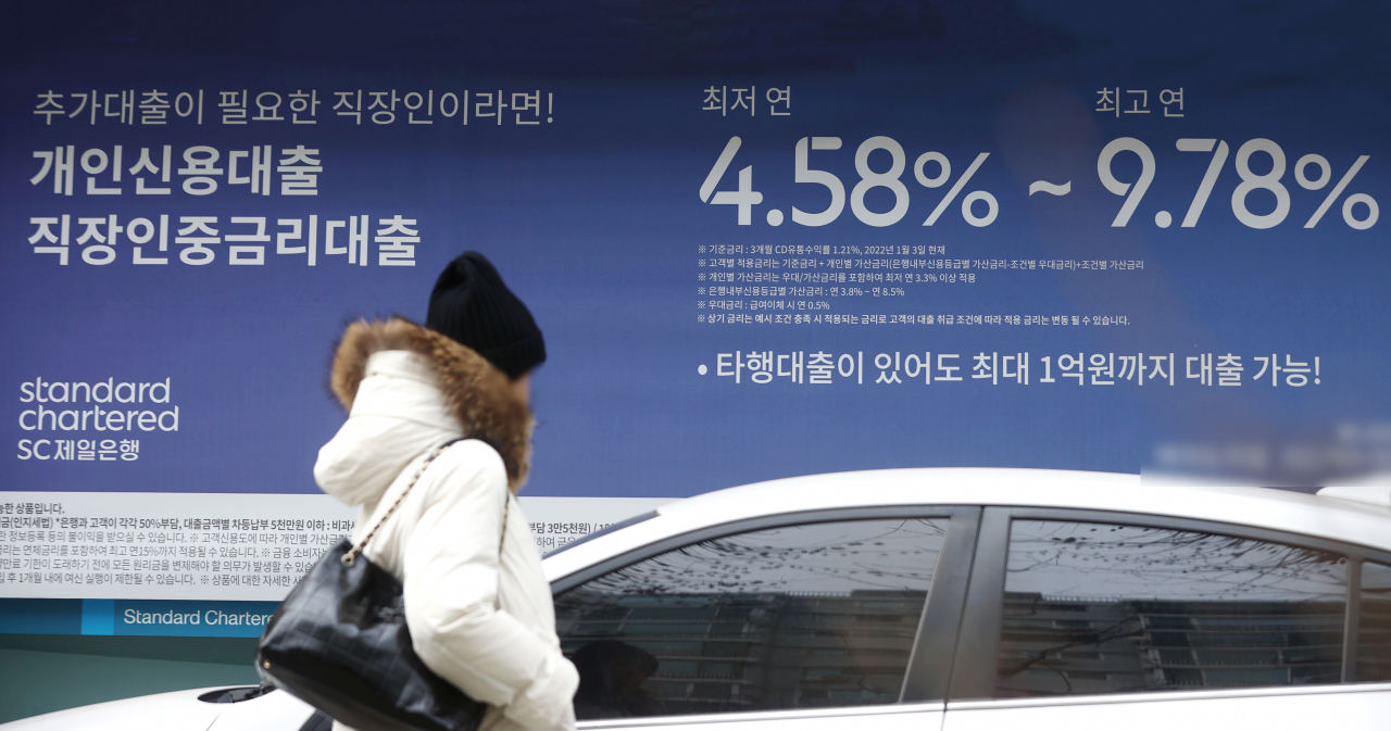 서울 한 시중은행의 대출 광고 안내문 앞을 시민이 지나가고 있다.[연합]