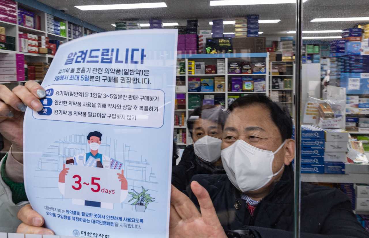 최광훈 대한약사회 회장이 지난해 12월31일 오전 서울 중구 남대문로의 한 약국에 감기약 수급 안정을 위해 판매를 제한한다는 내용의 안내문을 붙이고 있다. 안내문에는 약국 방문자를 대상으로 감기약 등 호흡기 관련 의약품을 3일에서 최대 5일분만 구매하고 필요 이상 구매하지 않도록 권장하는 내용이 담겼다. [연합]