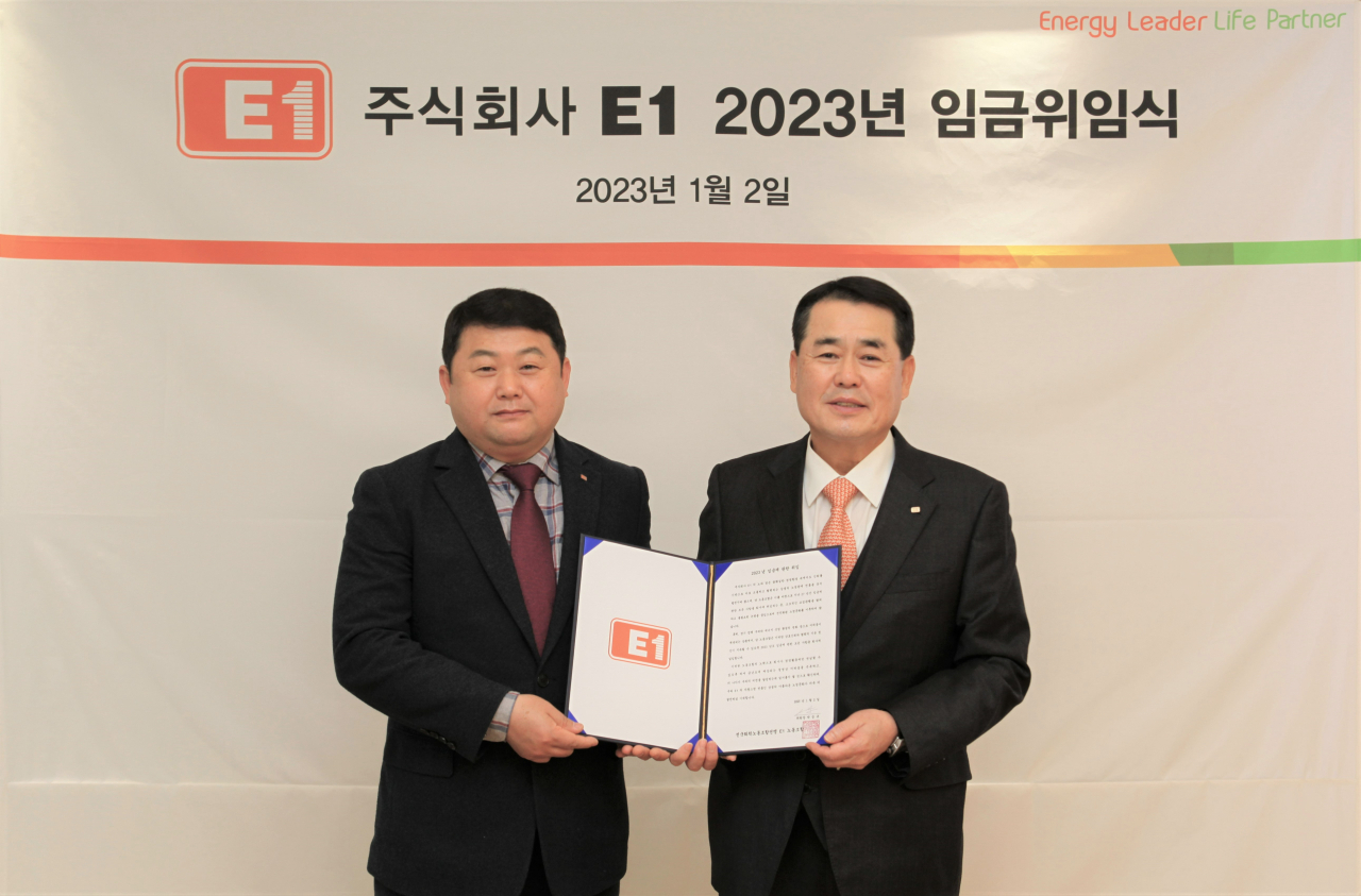 구자용(오른쪽) E1 회장과 박승규 E1 노조위원장이 2일 서울 용산구 소재 E1 본사에서 2023년도 임금에 관한 위임장을 들고 기념촬영을 하고 있다. [E1 제공]