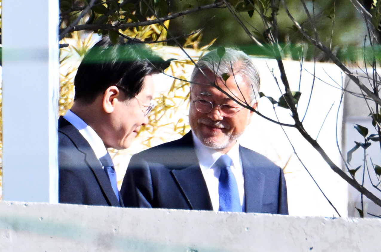 문재인 전 대통령 내외와 이재명 더불어민주당 대표 등이 지난 1월 경남 양산시 하북면 평산마을 문 전 대통령 사저에서 단체 사진 촬영에 앞서 대화하고 있다. [연합]
