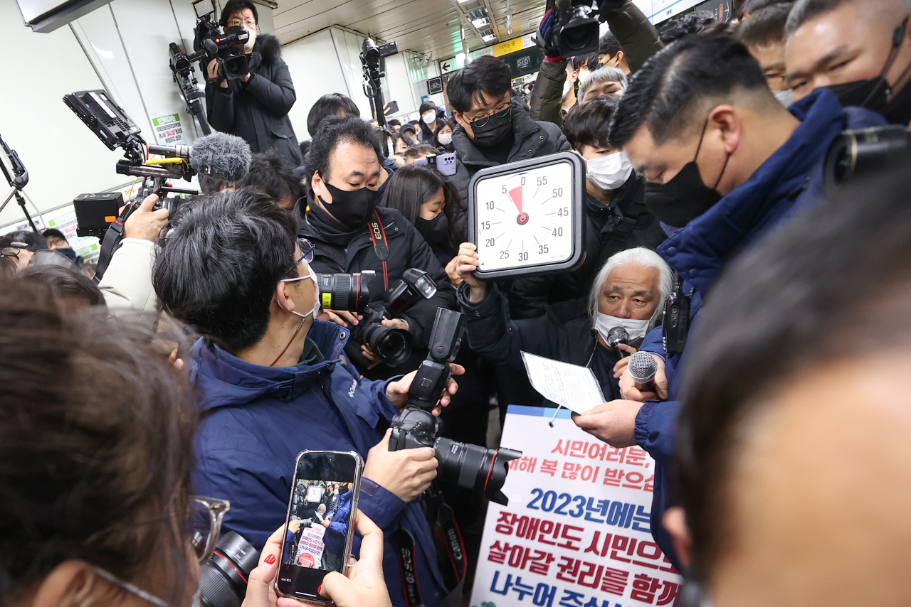 박경석 전국장애인차별철폐연대(전장연) 대표가 2일 오전 서울 지하철 4호선 삼각지역 승강장에서 5분이 표시된 시계를 들고 지하철 탑승을 시도하고 있다. 서울중앙지법은 지난달 19일 서울교통공사가 전장연과 이 단체 박경석 대표 등을 상대로 낸 손해배상 소송을 강제조정하며 전장연이 지하철 승하차 시위로 5분을 초과해 지하철 운행을 지연시키면 1회당 500만원을 공사에 지급하도록 했다. [연합]