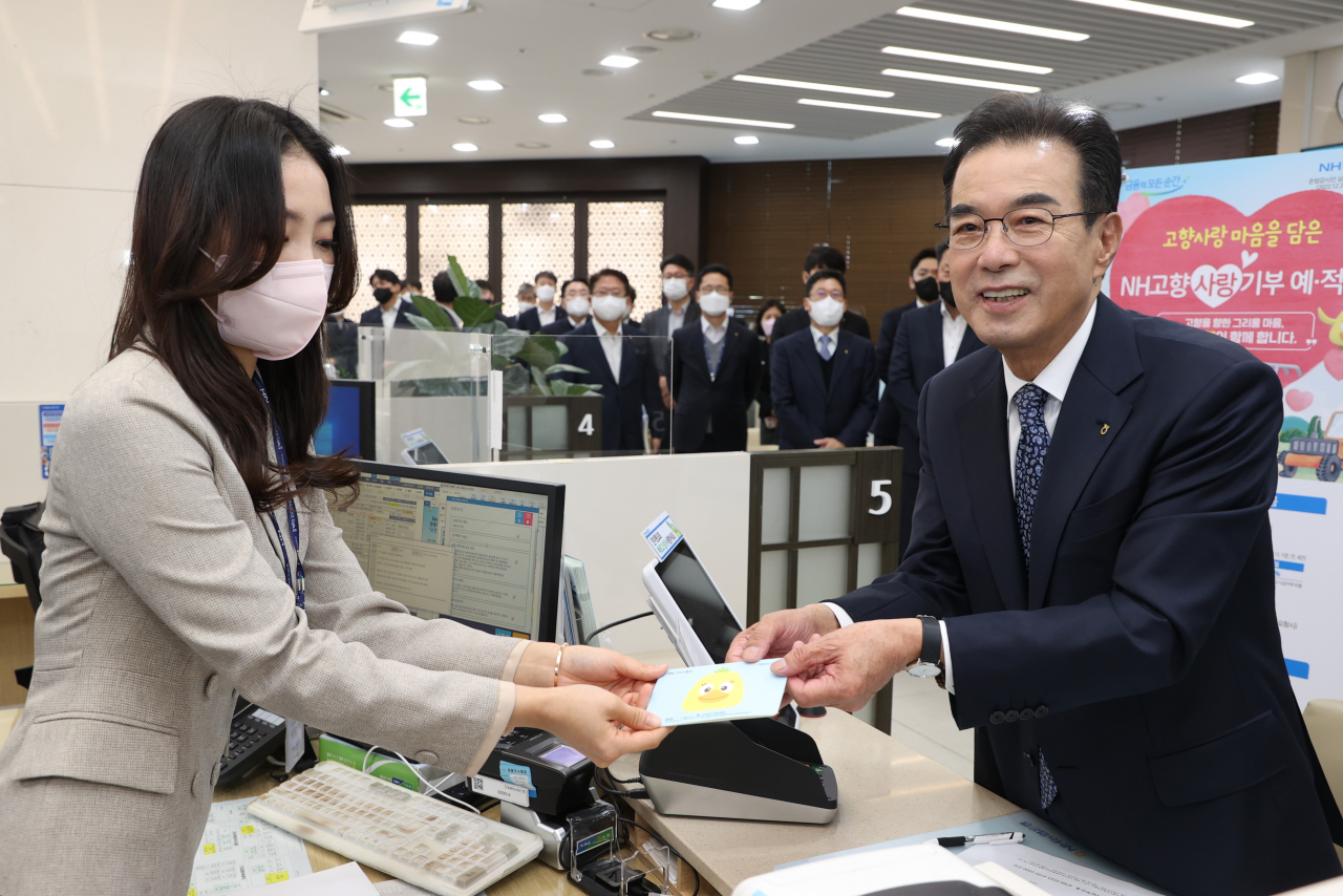 이성희(오른쪽) 농협중앙회장이 고향사랑기부제가 올해부터 시행됨에 따라 2일 서울 중구 농협은행 본점영업부를 방문해 고향사랑 기부금을 납부한 후 NH고향사랑기부 금융상품에 가입하고 있다. [농협중앙회 제공]