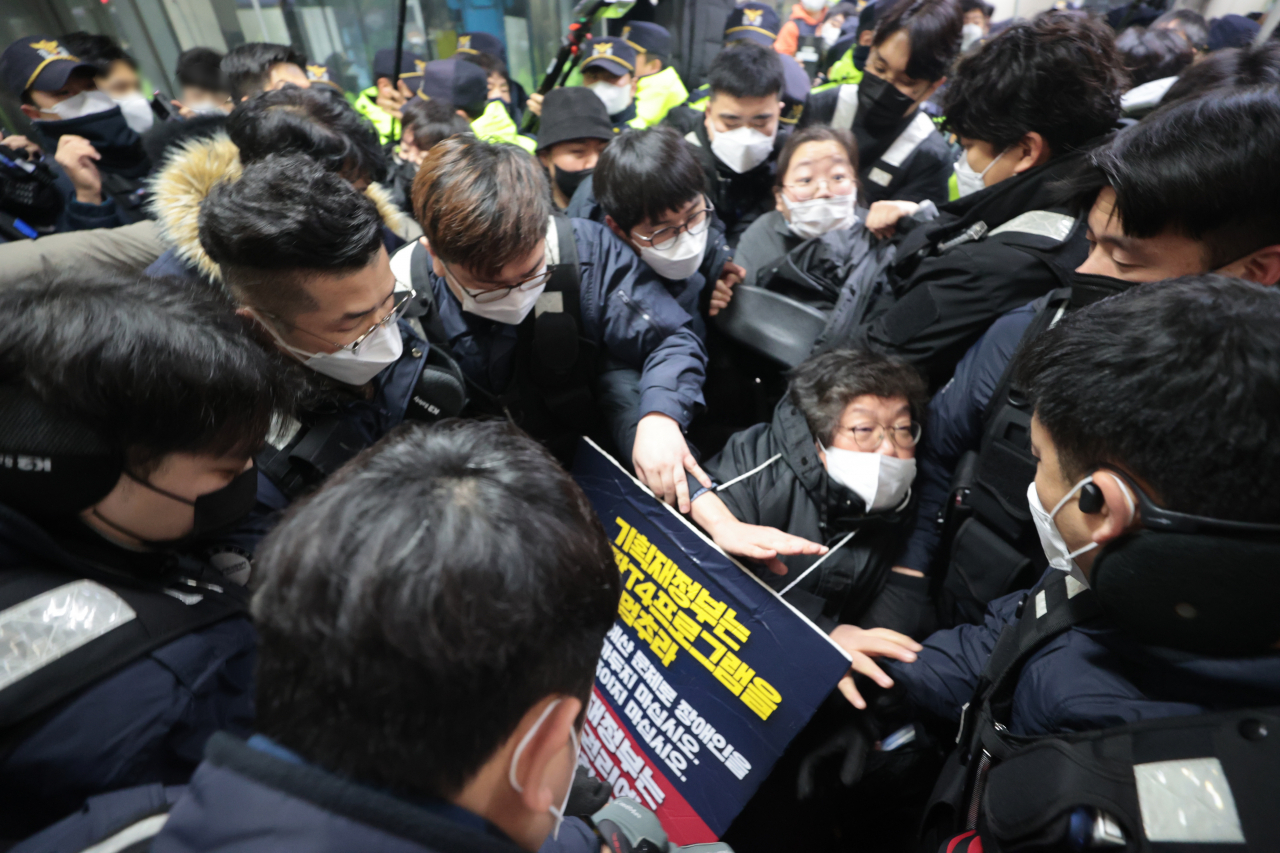 3일 오전 전국장애인차별철폐연대(전장연) 활동가들이 서울 4호선 동대문역사문화공원에서 지하철 탑승을 시도하다가 서울교통공사 측과 거칠게 대치하고 있다. 전날 전장연은 탑승을 막는 서울교통공사·경찰과 대치하며 13시간 가량 시위를 벌이다가 이날 오전 10시 30분에 시위를 재개할 것을 예고하며 해산했다. [연합]