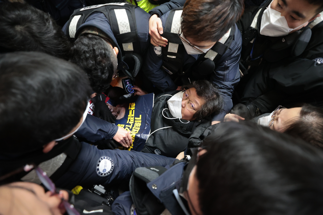 3일 오전 전국장애인차별철폐연대(전장연) 활동가들이 서울 4호선 동대문역사문화공원에서 지하철 탑승을 시도하다가 서울교통공사 측과 거칠게 대치하고 있다. 전날 전장연은 탑승을 막는 서울교통공사·경찰과 대치하며 13시간 가량 시위를 벌이다가 이날 오전 10시 30분에 시위를 재개할 것을 예고하며 해산했다. [연합]