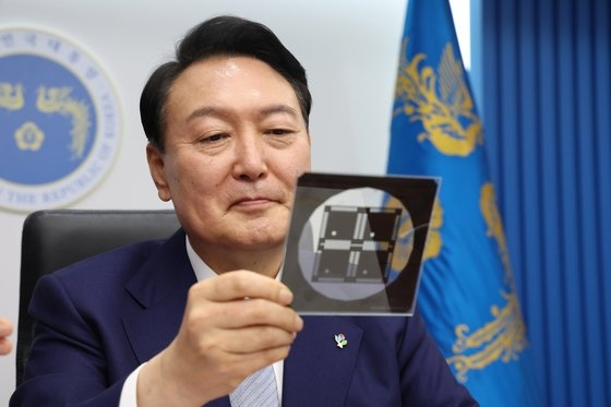 지난해 윤석열 대통령이 국무회의에서 반도체 포토마스크를 보고 있다. [대통령실]