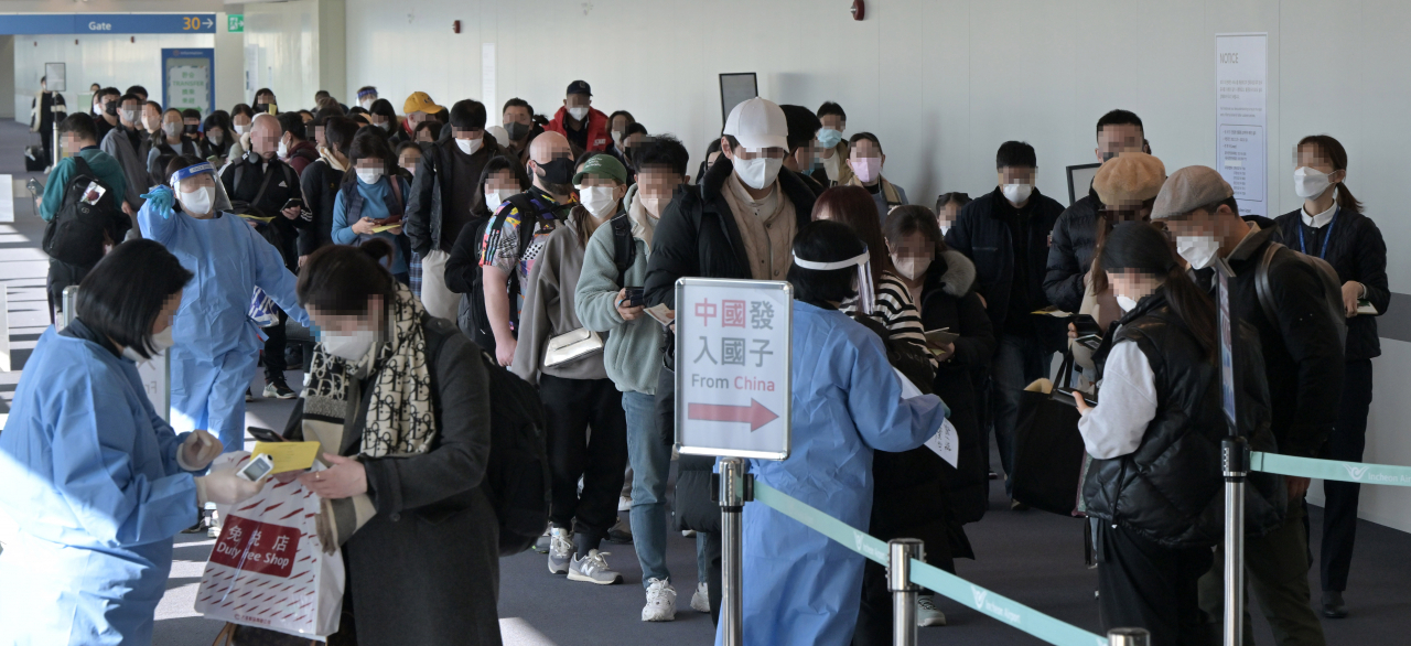 2일 인천국제공항 제1여객터미널 입국장에서 공항 관계자들이 중국발 입국자를 분류하고 있다. 방역당국은 이날부터 중국에서 항공편이나 배편으로 입국하는 모든 사람에 대해 코로나19 유전자증폭(PCR) 검사를 실시하는 등 고강도 방역 대책을 시작했다. [연합]