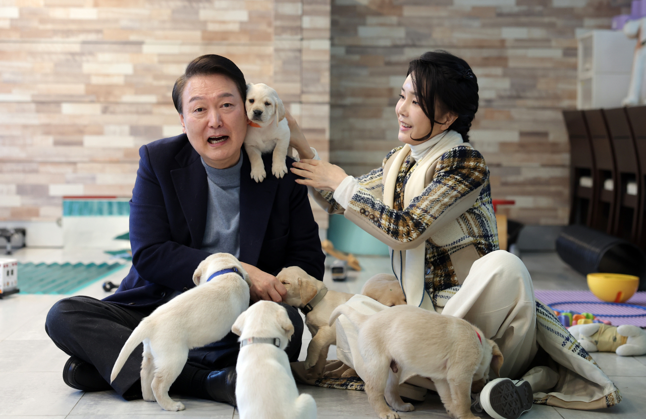 윤석열 대통령과 김건희 여사가 경기도 용인 삼성화재 안내견 학교에서 리트리버 강아지들을 살펴보고 있다. [연합]
