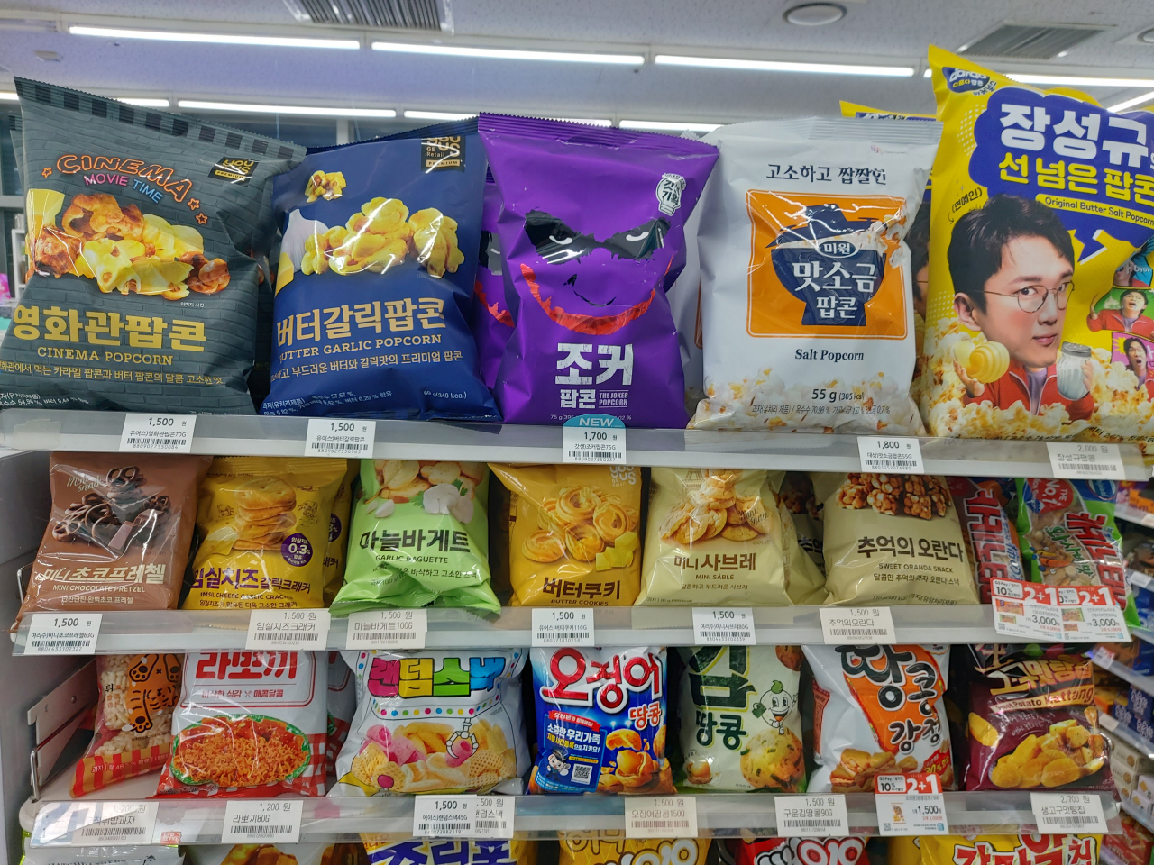 서울 마포구의 한 GS25 매장에서 판매되고 있는 GS25의 PB과자들의 모습(위에서 첫째·둘째줄) GS25 지점에서 판매되는 PB상품 팝콘과자의 경우 ‘유어스 영화관팝콘(70g)’은 1500원, ‘유어스 버터갈릭(60g)’은 1500원, ‘유어스 조커팝콘(75g)’은 1700원에 팔리고 있다. 김희량 기자