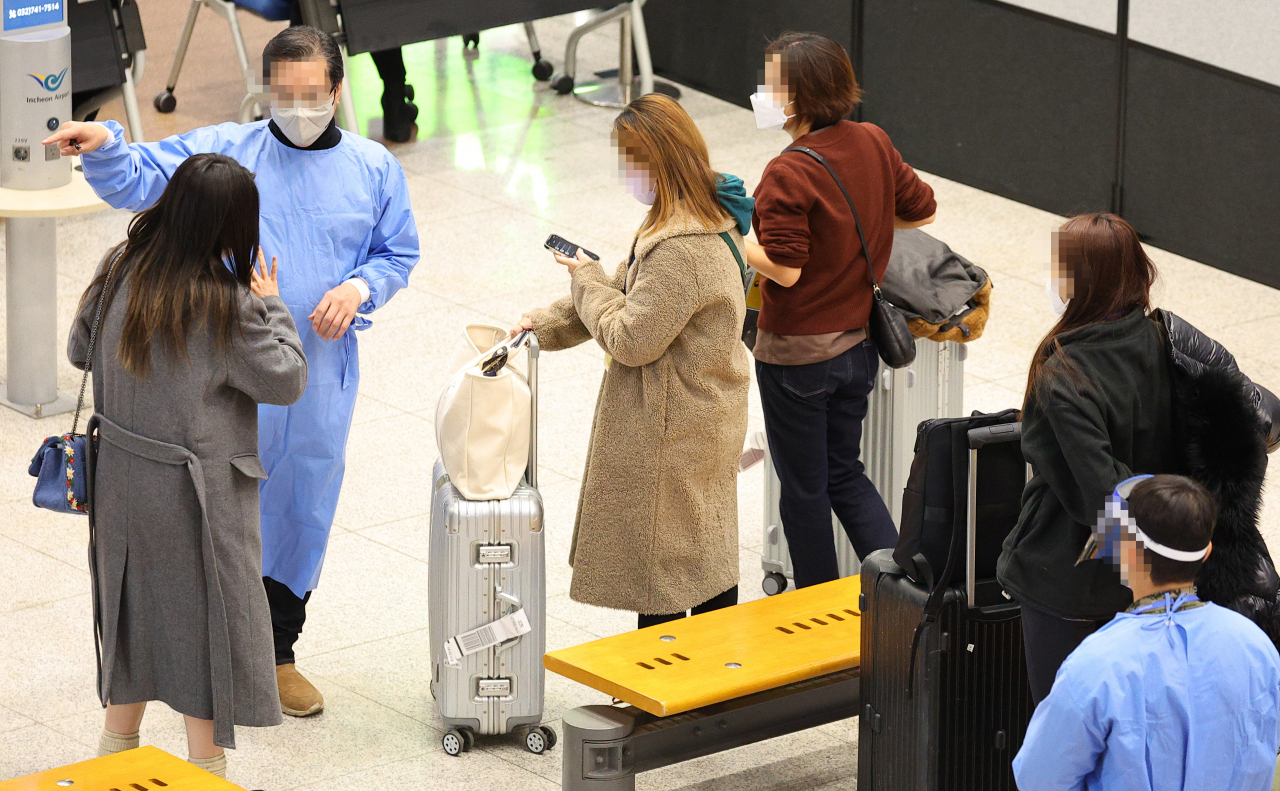 중국발 한국행 항공기에 탑승하는 모든 내·외국인의 코로나19 음성확인서 제출 의무화 첫날인 5일 오전 인천국제공항 제1여객터미널 입국장에서 방역 관계자가 중국발 입국객들을 안내하고 있다(사진은 기사 내용과 관련 없음). [연합]