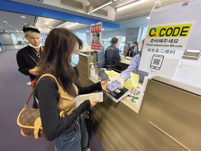6일 오전 인천공항 입국장 검역대에서 중국과 홍콩, 마카오서 입국한 외국인 여행객들이 검역정보사전입력시스템(Q-CODE·큐코드)을 찍고 있다. 중앙방역대책본부는 중국발 입국자에게 적용하던 PCR 검사 음성확인서 제시와 큐코드 입력 의무화를 7일부터 홍콩·마카오 출발 입국자에 대해서도 적용키로 했다. [공항사진기자단]