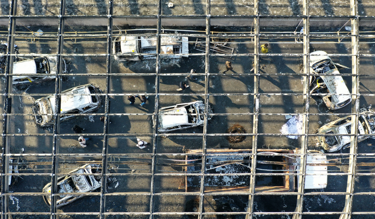 Police, fire department and National Forensic Service officials conduct a joint inspection at the scene of a fire on Dec. 30. The tunnel made of combustible plastic materials largely melted, leaving only the framework. (Yonhap)