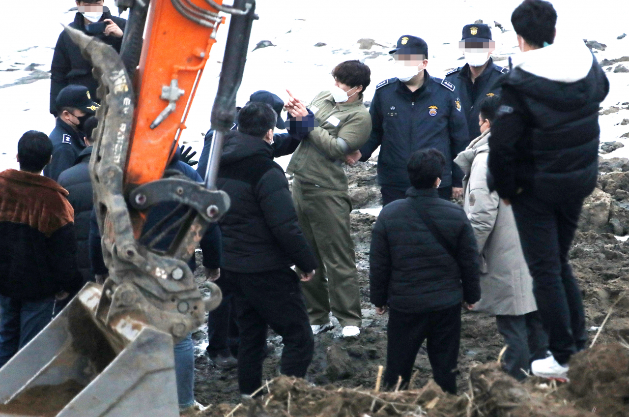 택시 기사와 동거녀를 살해한 혐의로 구속된 이기영이 6일 오후 경기도 파주 공릉천변에서 검찰 관계자들에게 시신을 매장했다고 진술한 부근을 손으로 가리키고 있다. [연합]