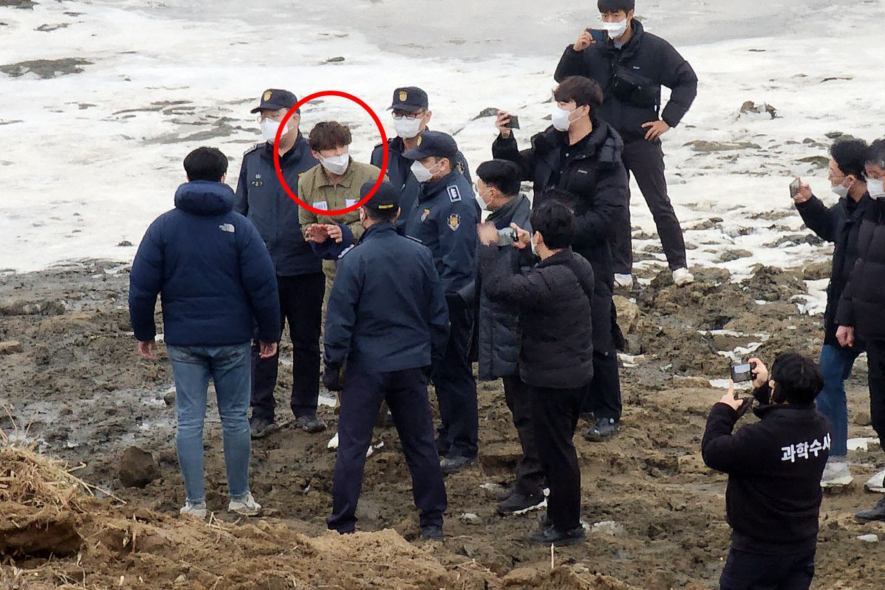 '택시기사·동거녀 살해' 혐의로 구속된 이기영(31)이 6일 오후 경기 파주시 공릉천변 동거녀 시식 수색 현장에서 의정부지검 고양지청 관계자들과 현장검증을 하고 있다. [연합]