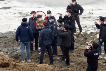'택시기사·동거녀 살해' 혐의로 구속된 이기영(31)이 6일 오후 경기 파주시 공릉천변 동거녀 시식 수색 현장에서 의정부지검 고양지청 관계자들과 현장검증을 하고 있다. [연합]