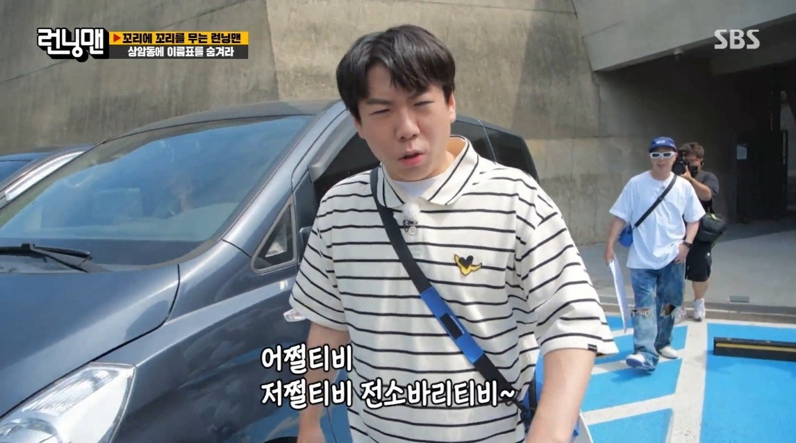 런닝맨 출연진이 장애인 전용 주차구역에 주차된 차량 사이를 지나고 있는 모습 [런닝맨 방송화면 캡처]