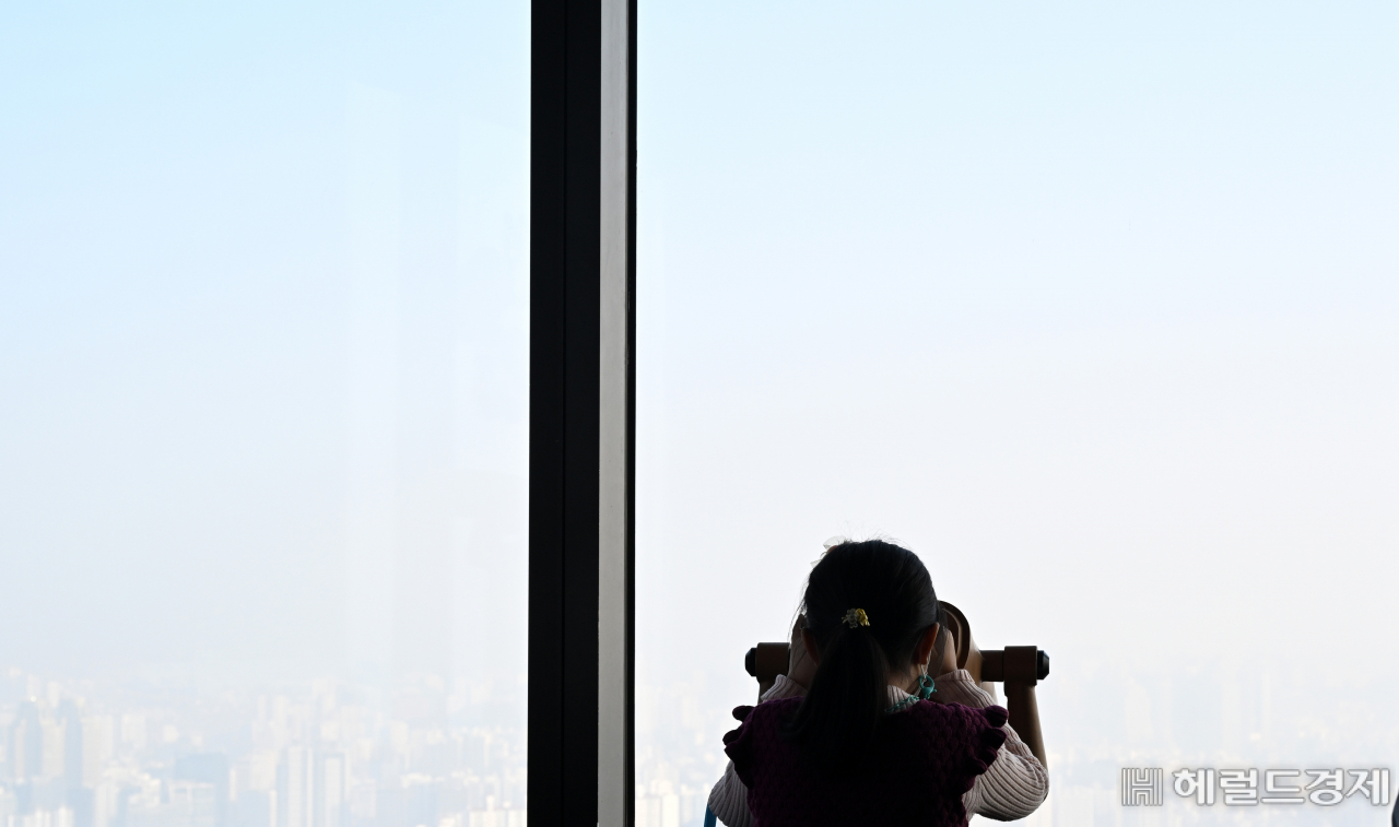 전망대를 찾은 아이가 서울 도심을 살펴보지만 미세먼지로 인해 뿌연 모습만 보이고 있다.