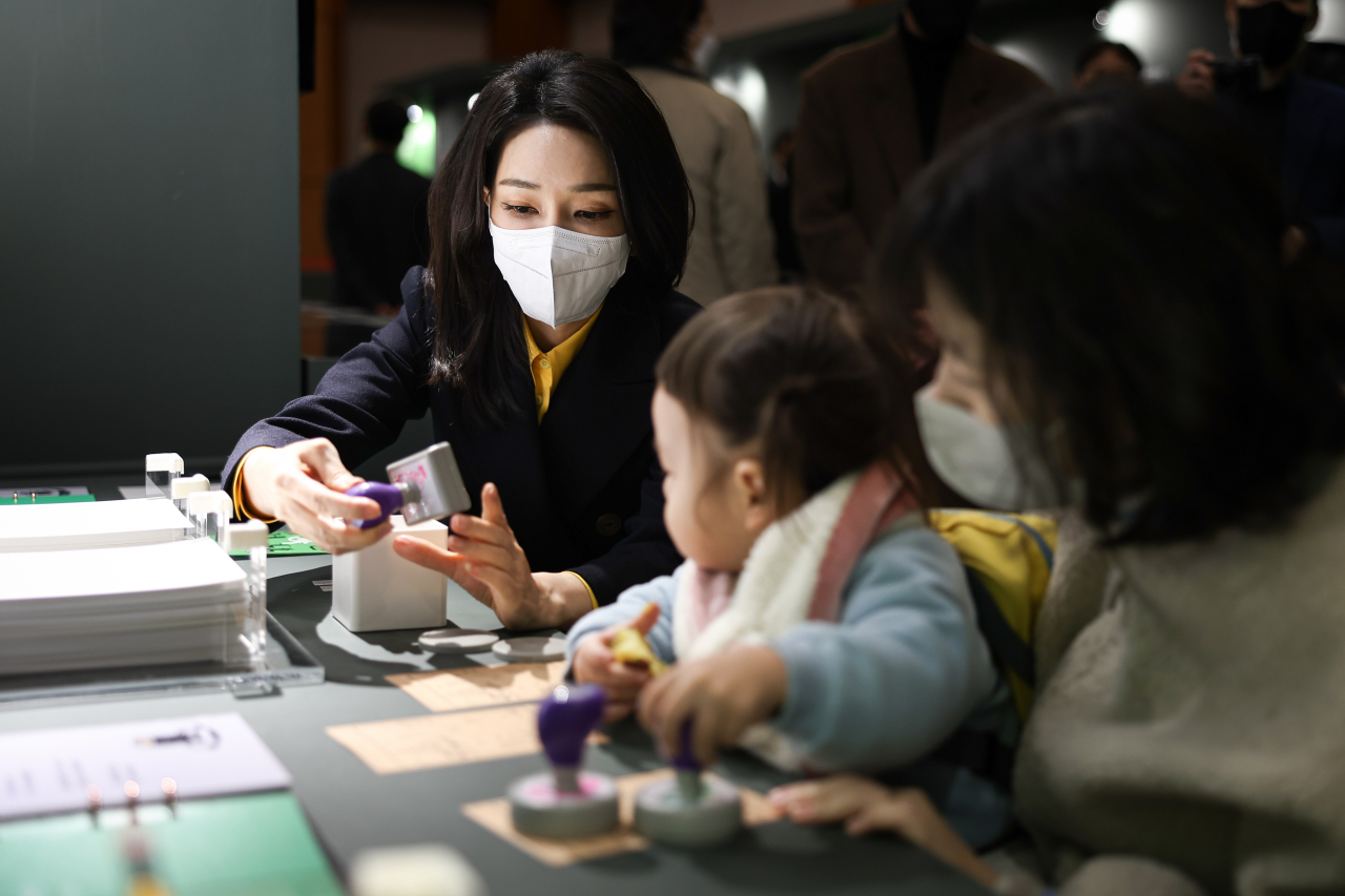 윤석열 대통령 부인 김건희 여사가 9일 청와대 춘추관에서 열린 '청와대 춘추관 문학특별전시회'를 찾아 이상,염상섭,현진건, 윤동주 등 근현대 문인들의 대표작품을 살펴본 뒤 관람객들과 문학도장 찍기 체험을 하고 있다. [대통령실]