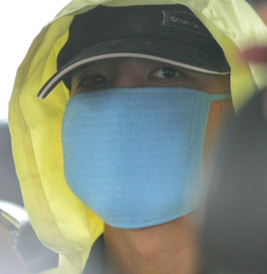 Yoo Young-chul leaves a police station in Seoul to participate in a crime scene reenactment, July 2004. (Yonhap)