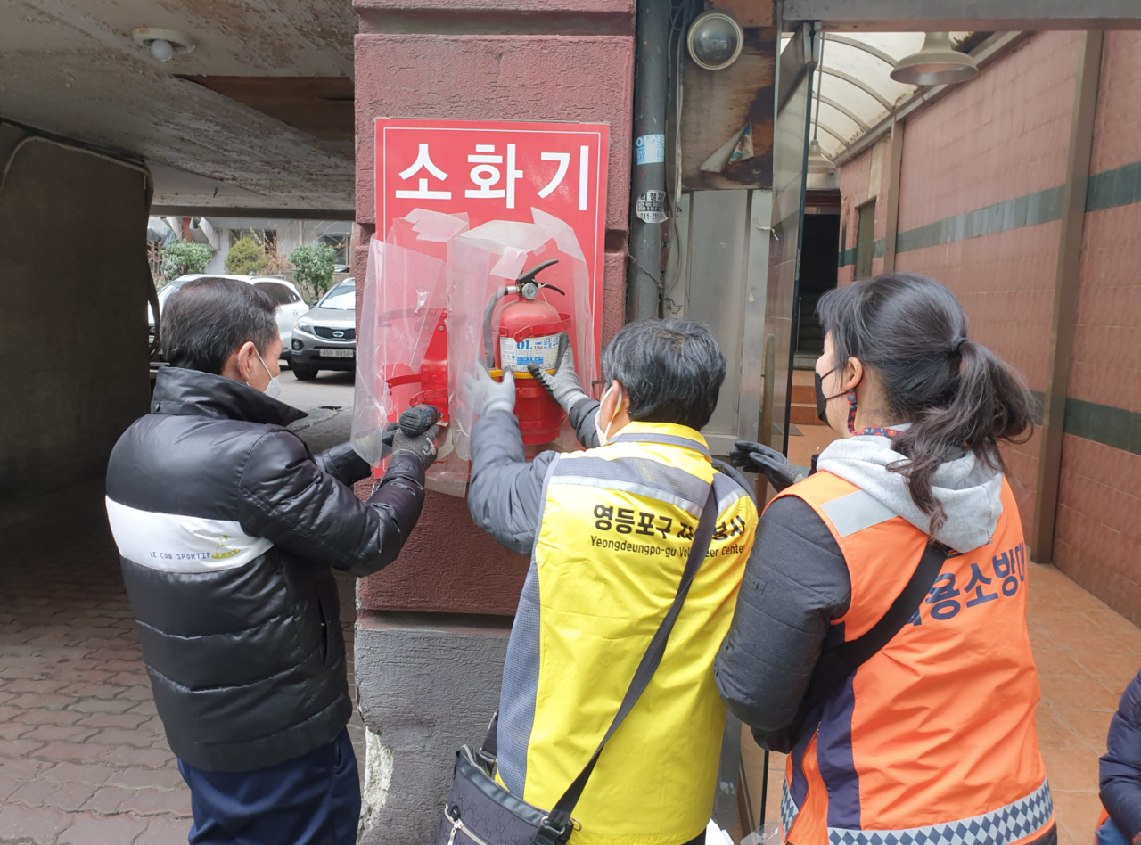 12일 영등포구에서 보이는 소화기를 시민봉사단이 점검·관리하고 있다. [서울시 제공]