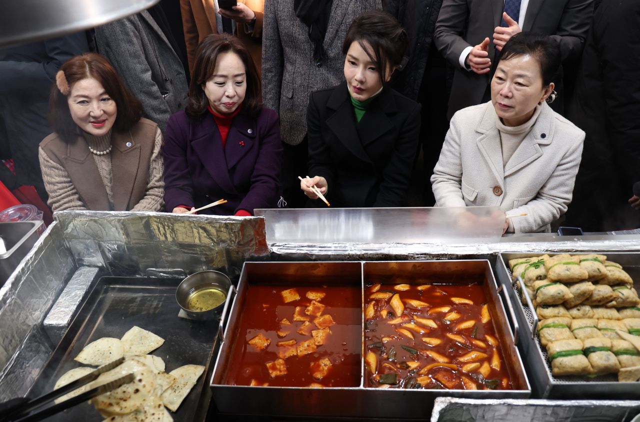 김건희 여사가 11일 대구 서문시장에서 납작만두 조리과정을 지켜보고 있다. [연합]