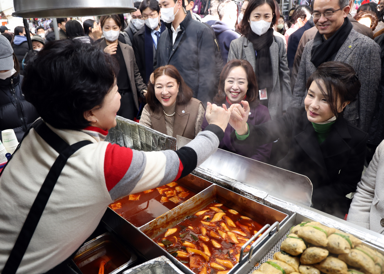 김건희 여사가 11일 대구 서문시장에서 만두 등 음식을 맛본 뒤 재방문을 약속하며 상인과 새끼손가락을 걸고 있다. [연합]