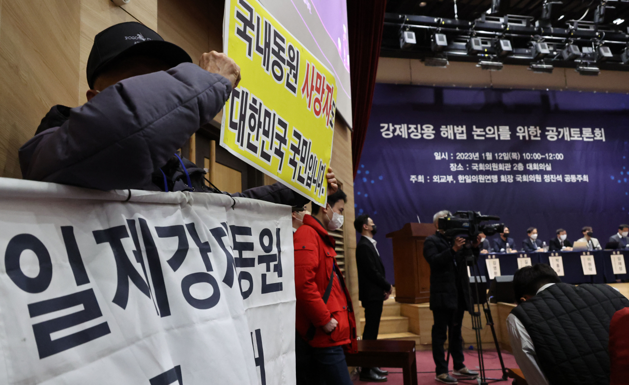 12일 오전 서울 여의도 국회 의원회관에서 열린 강제징용 해법 논의를 위한 공개토론회에서 참석자들이 피켓을 들고 있다. [연합]
