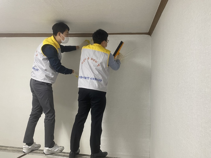 한국동서발전 직원들이 ‘신박한 에너지 정리’ 수혜 가구인 울산시 동구 긴급위기보호아동 위탁 저소득층 가정 집수리를 위해 도배를 하고 있다. [사진=한국동서발전]