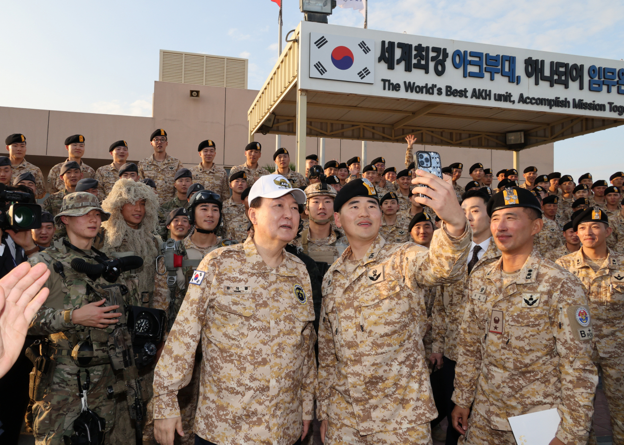 아랍에미리트(UAE)를 국빈 방문 중인 윤석열 대통령이 15일(현지시간) 현지에 파병중인 아크부대를 방문, 명예 아크부대원 상징 모자를 쓰고 장병들과 사진을 찍고 있다. [연합]